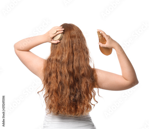 Young redhead woman applyin...