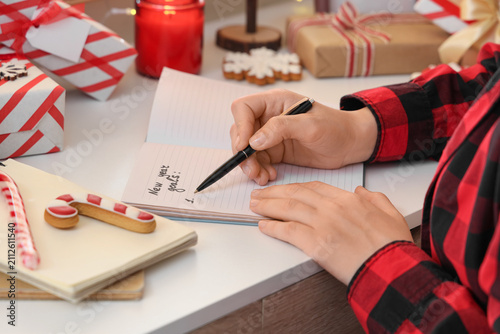 Young woman writing New Yea...