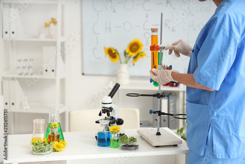 Female scientist with flasks of samples, sunflower seeds and sprouts working ...