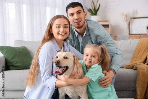 Happy family with cute Labrador dog at home