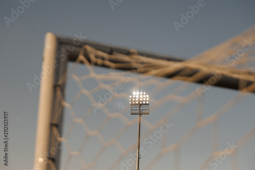 Football stadium floodlights shining at night, soccer match atmosphere and sports stadium illumination concept