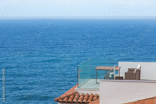 Canvastavla Terrazzino con tavolino e siede affacciato sul mare