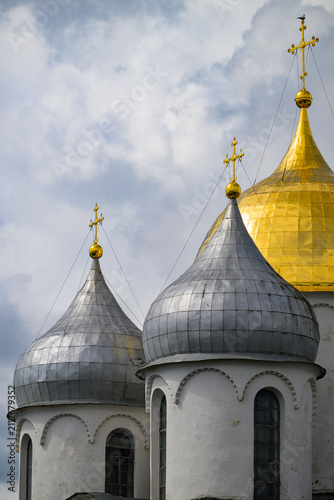 Fotografie White stone church with domes under cloudy sky