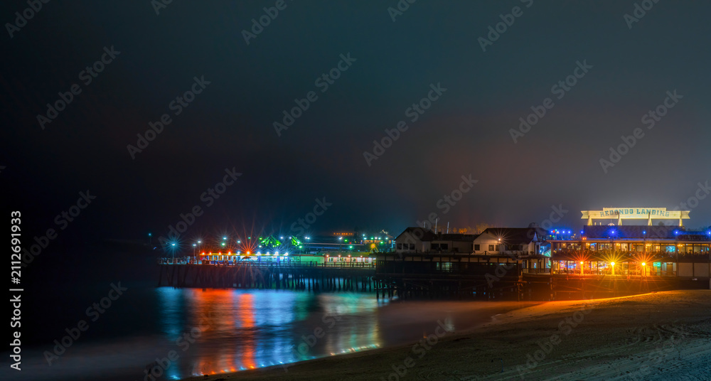 Fototapeta premium Redondo Beach pier illuminated at night with colorful reflections on the water