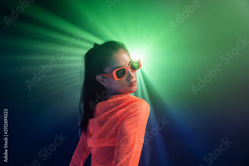 Latin woman urban dancer in neon light and sunglasses