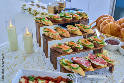 Canvastavla Gourmet salmon and prosciutto bruschetta appetizers beautifully arranged on wooden step risers for a catering event