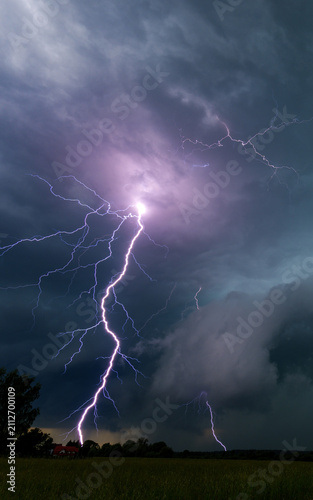 Foto Vertical view of a powerful lightning strike bolts flashing down to the ground d