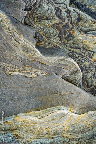 Abstract metamorphic rock texture with swirling stone layers