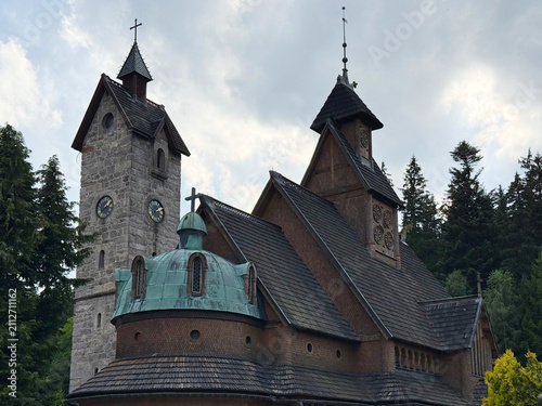 Historic Wang Church and Stone Bell Tower in Karpacz, Lower Silesian Voivodeship, Poland under Blue Sky with Clouds – Famous Norwegian Stave Church, European Architectural Landmark