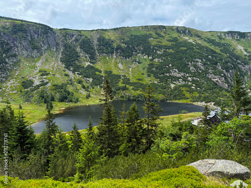 Scenic Mały Staw Mountain Lake in the Karkonosze Mountains with Crystal Water, Green Slopes and Dramatic Summer Sky