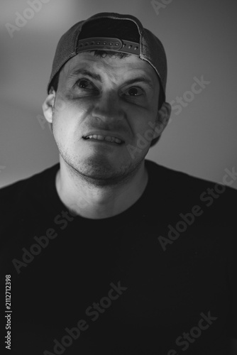 Foto Man with skeptical expression wearing baseball cap