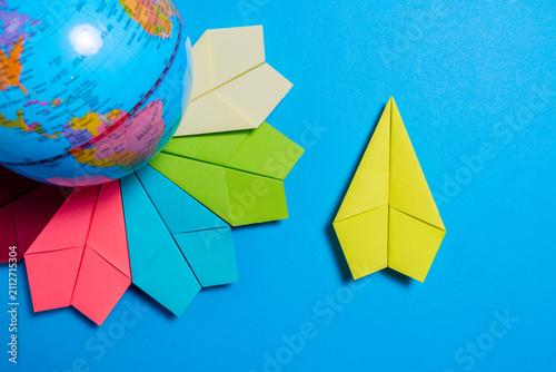 Global Travel Concept with Colorful Paper Planes and World Globe