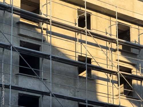 Building under construction with scaffolding in morning light