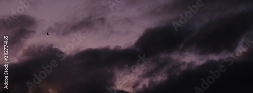 Photography Moody purple dusk sky with dark storm clouds rolling in during a dramatic autumn