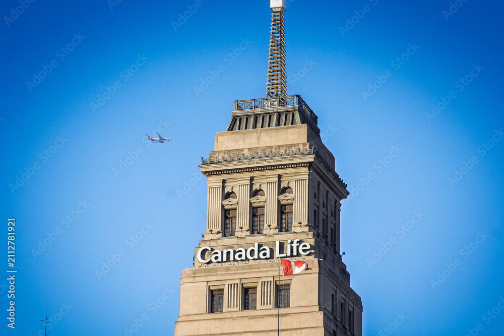 Obraz premium TORONTO, CANADA - DECEMBER 20, 2016: Canada Life sign displayed on the company's Toronto headquarters, with a Canadian flag on the facade, Canada Life is a canadian insurance company.
