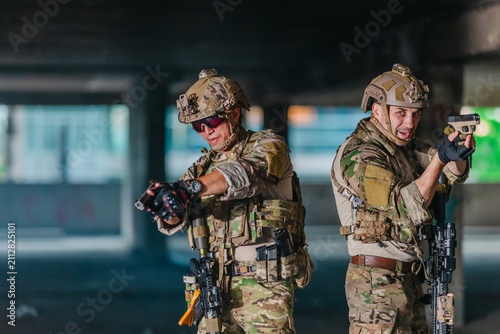 Fotografie Military tactical operator aims pistol during sidearm drill in abandoned concret