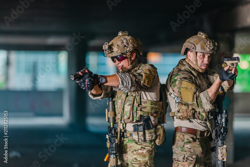 Fotografía Military tactical operator aims pistol during sidearm drill in abandoned concret