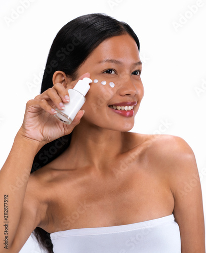 Canvas Print Beautiful asian woman using moisturizer in skincare routine