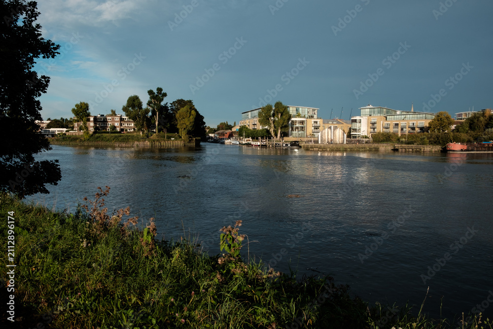 Obraz premium Thames river waterfront with residential buildings and boats