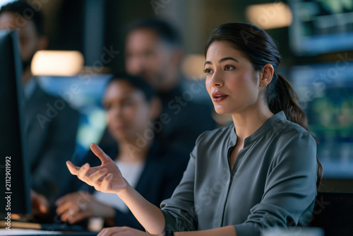 Elegant female operations director reviewing alternative facility plans beside architectural models showcasing climate ready business continuity and operational resilience