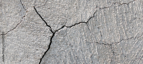 Gray concrete wall texture with deep cracks