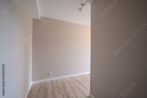 Fotografía clean, empty corner of room with beige walls, light wood‑look flooring, white baseboards, recessed ceiling