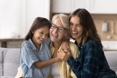 Fotografía Loving grown-up 30s daughter, preteen 12s granddaughter hugging older 65s retired granny congratulates her on birthday cuddling tightly, express caress, feeling love, showing care and support
