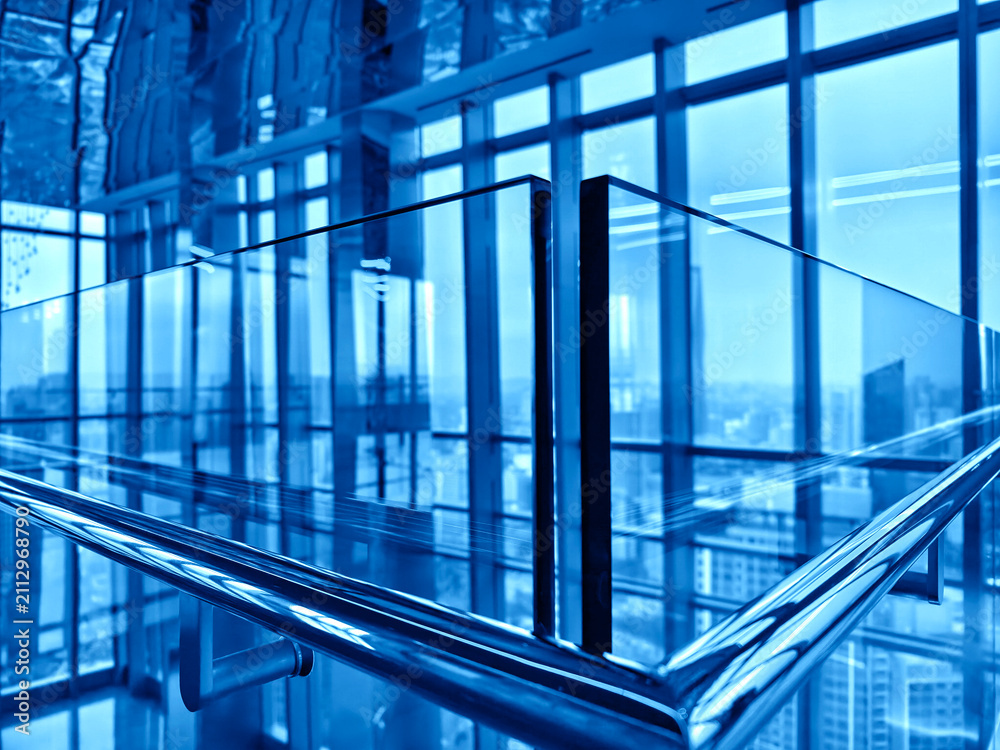 Fototapeta premium Spacious glass atrium with reflections on polished floor and panoramic windows. Empty lobby features
