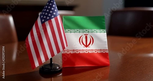 Small American and Iranian Flags Displayed Together on Wooden Table for Diplomacy.