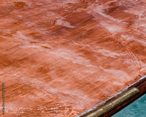 Seamless lacquered teak boat deck with high-gloss varnish and water reflections for coastal design backgrounds and nautical themes