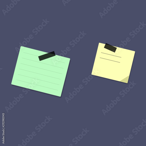 Two separate green and yellow sticky notes with tape on dark background reminder stationery communication
