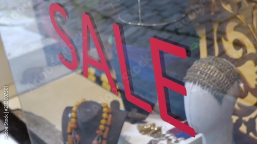 Shop displays sale signs in a busy market area
