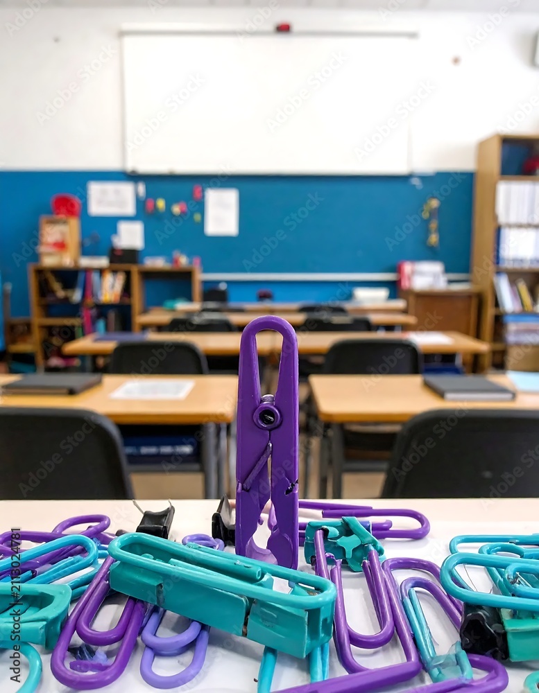 Fototapeta premium Purple and teal plastic laundry clothespins on a classroom desk.