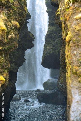 Vertical photo of the entrance to the Gljufrabui waterfall inside a canyon near Seljalandsfoss on a March day