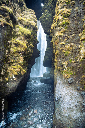 Vertical photo of the entrance to the Gljufrabui waterfall hidden in a canyon near Seljalandsfoss on a March day