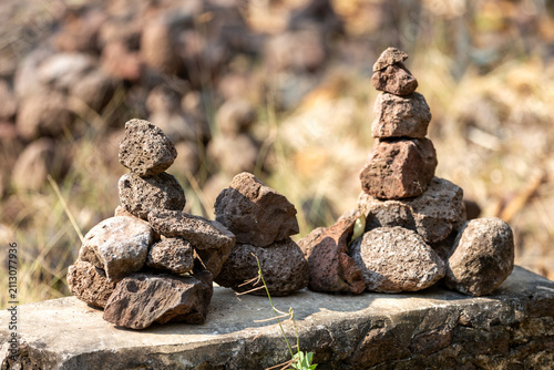 Photography Small rock cairns stacked on a concrete structure in a natural environment