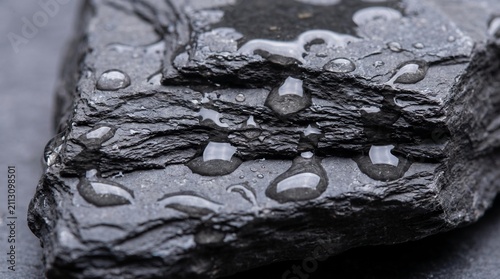 Macro perspective of water interacting with layered shale rock, showcasing natural textures