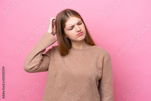 Foto Teenager Russian girl isolated on pink background having doubts while scratching