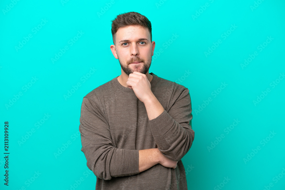 Fototapeta premium Young caucasian man isolated on blue background having doubts and thinking