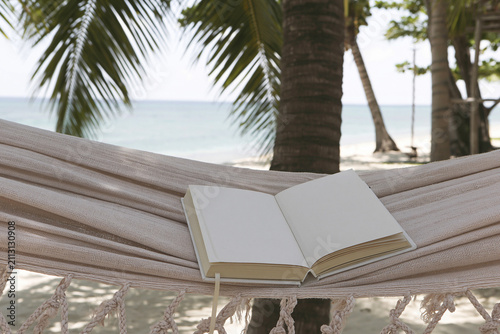 Blank white hardcover book mockup on hammock by the beach