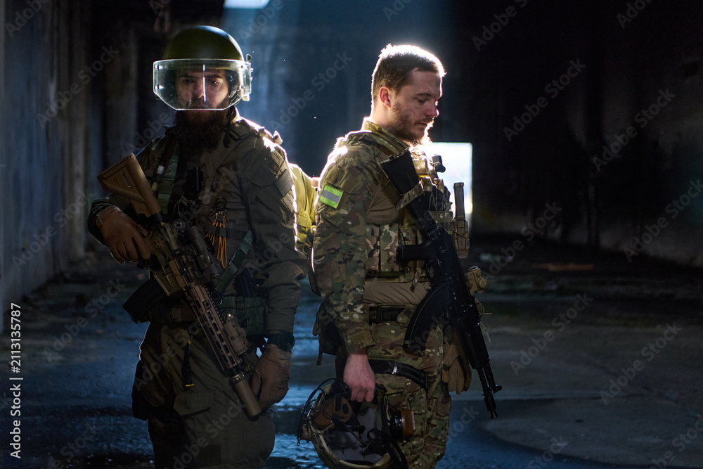 Obraz premium Two Tactical Soldiers Back to Back in Dark Urban Building With Rifles and Combat Gear