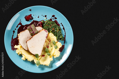 Roasted turkey breast with mashed potatoes and cranberry sauce on blue plate