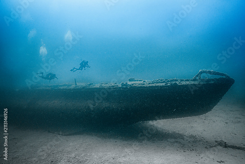Fotografie Divers exploring historic rubis submarine wreck underwater
