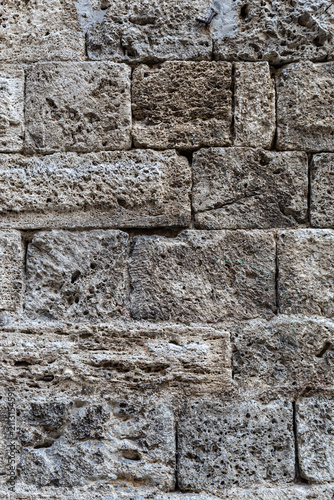 Ancient Stone Wall Texture with Weathered Masonry Blocks, Historic Architectural Background Featuring Rough Granite Surface and Traditional Medieval Construction