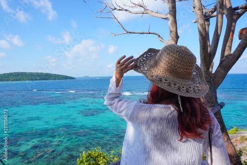Konstfotografi Red haired woman wears woven hat, gazing at ocean