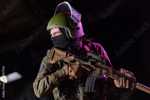 Fotografie Tactical Soldier With Assault Rifle in Night Urban Operation Wearing Helmet and