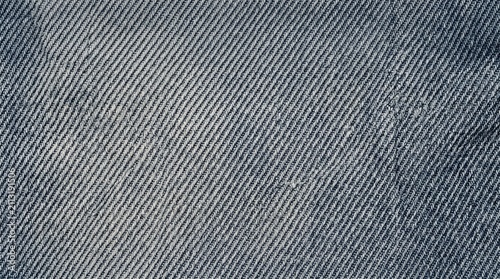 Faded bluish-gray neutral washed denim canvas displaying detailed diagonal twill weave, photorealistic macro photography creates commercial stock material.
