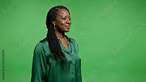 Confident Black woman with braided hair wearing a green silk blouse posing against a solid green background