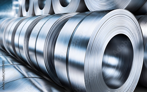 Metal coils stacked in a factory warehouse. Industrial raw material storage shows organised supply chain logistics for manufacturing and construction sectors. Precision metalwork in production