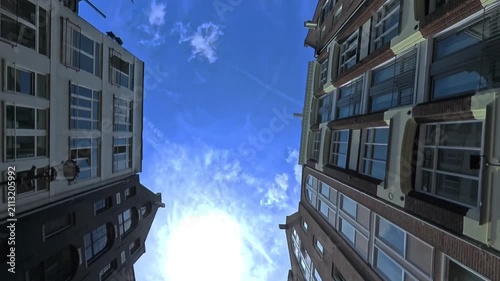 A view from below of Dutch historical architecture and a sunny sky in Amsterdam